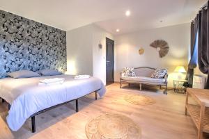 a bedroom with a large bed and a couch at Les Hirondelles in Saint-Cernin-de-Labarde