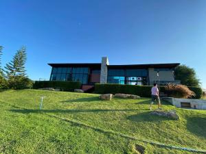 a man standing in the grass in front of a building at ไร่ภูพันดาว Phupandao Farmstay in Ban Mai