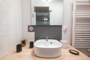 a bathroom with a white sink on a wooden counter at Les Hirondelles in Saint-Cernin-de-Labarde