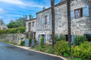 an old stone house on the side of a road at Les Hirondelles in Saint-Cernin-de-Labarde