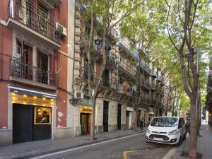 een witte auto geparkeerd in een straat naast een gebouw bij Parallel - Family Flat 2 rooms in Barcelona