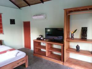 TV at/o entertainment center sa Bird of Paradise Bungalows