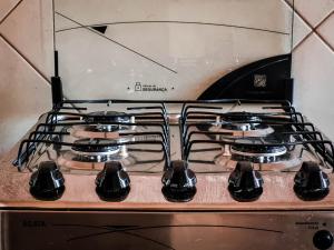 a stove top with four burners on it at Hostel-Agência Chapada Backpackers in Lençóis