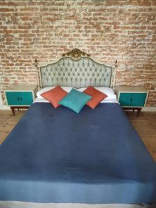 a blue bed with two pillows and a brick wall at HOTEL Boutique Casablanca Adrogué in Adrogué
