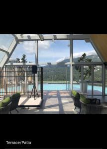Una vista de una piscina desde una casa con sillas. en Windmill upon hill, Genting Highland, en Genting Highlands