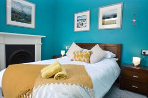 a bedroom with a large bed with blue walls at Crossaig Farm House in Crossaig