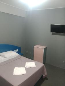 ポルト・アレグレにあるHotel Restのタオルが敷かれたベッドが2つある寝室