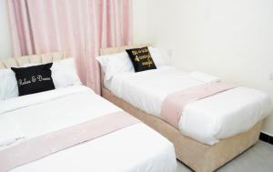 two beds sitting next to each other in a room at Olive Homes Stylish 3 Bedroom Getaway in Lake View Estate