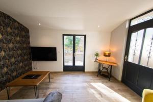 a living room with a table and a tv at La petite longère La mercerie in Bourges