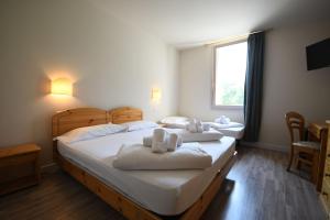 ein Schlafzimmer mit zwei Betten, auf denen Handtücher liegen in der Unterkunft Hotel Saisera in Valbruna