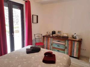 a bedroom with a bed and a dresser with pink curtains at B&B Maison Colette Valgorge in Valgorge