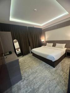 a hotel room with a large bed and a chair at درة الشرق للشقق المخدومة in Al Madinah