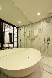 a white bathroom with a tub and a shower at Hotel Infini in Seoul