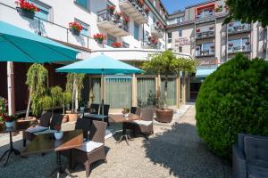 インターラーケンにあるHotel Du Nordのパティオ(テーブル、椅子、青い傘付)