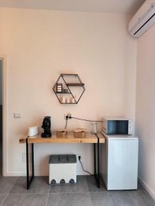 una scrivania in una stanza con un frigorifero e una lampada di Room 48 Bologna a Bologna