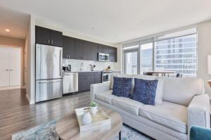 Una sala de estar con un sofá y una cocina. en Luxury Apt with Balcony In Seaport, en Boston
