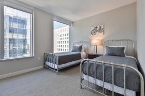 Un dormitorio con dos camas y una ventana. en Luxury Apt with Balcony In Seaport, en Boston