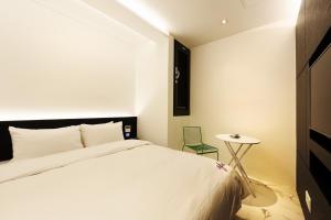 a bedroom with a white bed and a small table at Hotel Infini in Seoul