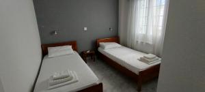 two beds in a small room with a window at Αλέξανδρος 2 in Myrina