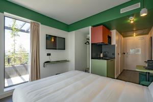 巴黎All Suites Appart Hôtel et Hôtel - Paris 13 - Porte d'Italie的带一张大床和一扇窗户的卧室