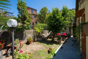 een tuin met bloemen en bomen en een gebouw bij Sweet Tuscany I Due Gigli in Arezzo