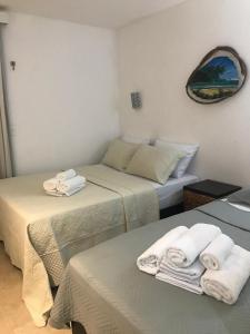 zwei Betten in einem Zimmer mit Handtüchern darauf in der Unterkunft Taiba Beach Resort - Ap 106 BL A - IMOB TEMPORADA in Taíba