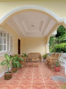 Un patio con sillas y mesas de mimbre sobre un piso de ladrillo. en Cajigal Farmhouse - high speed converge internet and AC in 2 bedrooms, en Badoc