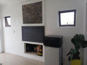 a living room with a fireplace and a flat screen tv at On 36 Neethlingshof in Cape Town