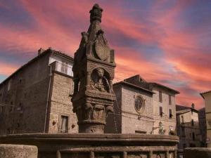 a statue in front of a building with a sunset at La Peonia in Vitorchiano