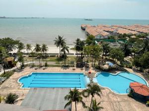 une vue aérienne d'un complexe hôtelier avec piscine et plage dans l'établissement Glory Beach Duplex Ocean View - 8Pax 3BR & FREE Disney Hotstar, à Port Dickson