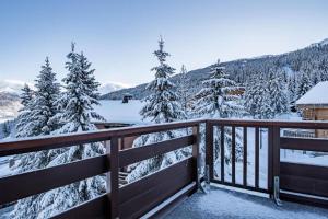 a balcony with snow covered trees and a cabin at Résidence Grand Bois A916 Clés Blanches in Courchevel +4 photos