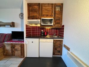 a small kitchen with a sink and a microwave at Résidence Grand Bois A916 Clés Blanches in Courchevel