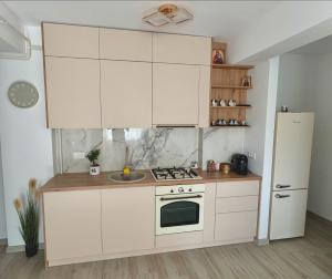 a kitchen with white cabinets and a refrigerator at Adam Home Ap in Fălticeni
