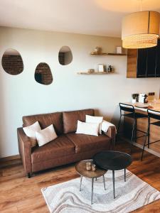 a living room with a brown couch and a table at La Terrasse de l'Esterel in Mandelieu-La Napoule