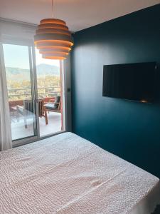 a bedroom with a bed and a flat screen tv at La Terrasse de l'Esterel in Mandelieu-La Napoule