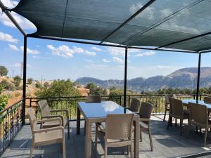 a patio with tables and chairs and a view of mountains at Nemrut Çesme Otel Restaurant Cafe in Adıyaman
