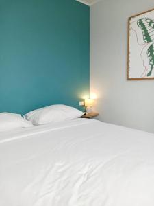a bedroom with a white bed with a blue wall at 2BR Aparment Near The Beach T2-717 in Phuket Town