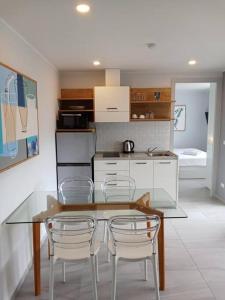 a kitchen with a glass table and white chairs at 2BR Aparment Near The Beach T2-717 in Phuket Town