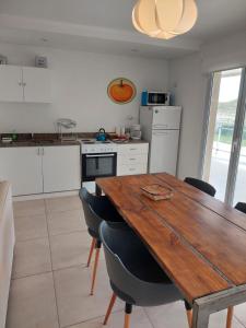 a kitchen with a wooden table and chairs at Condominio del Faro - Quequen in Necochea