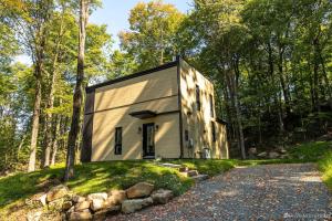 a small house on a hill in the woods at Private Hot Tub Chalet Harmonia in Brownsburg