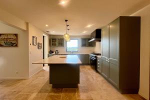 a kitchen with a large island in the middle of it at LE Mas Jas magnificent Mas Provençal - Lauris in Lauris +27 photos
