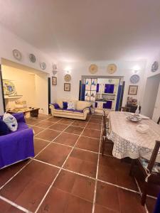 un soggiorno con pavimento piastrellato, divani e tavoli. di Villa La Perla Capri a Capri