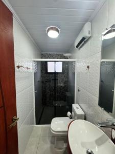 a bathroom with a shower and a toilet and a sink at Chalés Marrevi HomeHotel in São José dos Pinhais