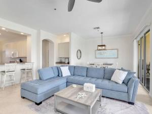 a living room with a blue couch and a table at Elevated 886 Amazing Condo Park View in Marco Island