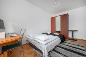 a bedroom with a bed and a desk and a computer at Apartament Emily Brzeźno in Zaspa