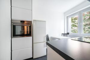 a kitchen with a refrigerator and a black counter top at Apartament Emily Brzeźno in Zaspa