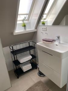 Un baño con lavabo y estante con toallas. en Küstenglück Sylt D1, en Westerland