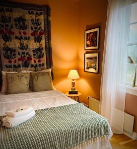 a bedroom with a bed with a blanket and a window at Konstnärsvåningen i Villa Sol in Borgholm
