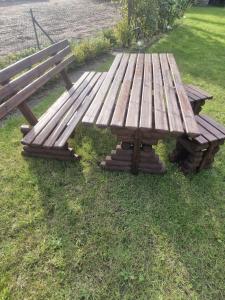 una mesa de picnic de madera y un banco en el césped en Sommerhaus, en Bremervörde