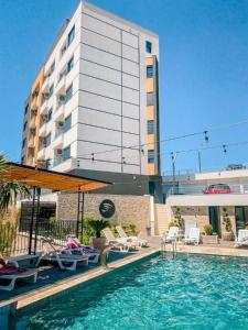 a swimming pool with chairs and a building at Eagles Locus Apartments in Ulcinj